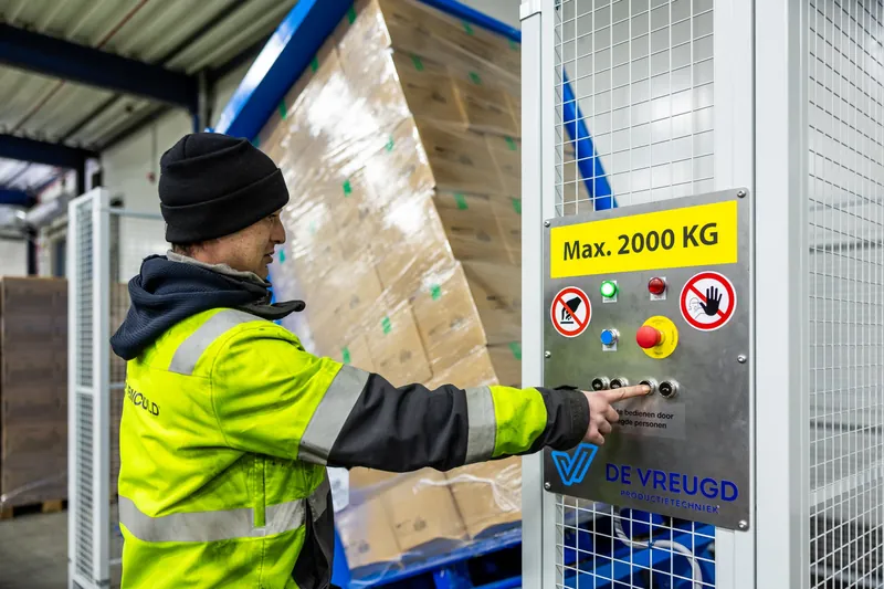 Medewerker bedient het paneel van de PalletRotator bij het kantelen van een pallet
